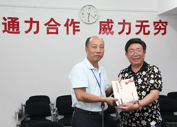 莫院长代表广州市饲料协会向毛总赠予《广州市饲料企业风范》留念